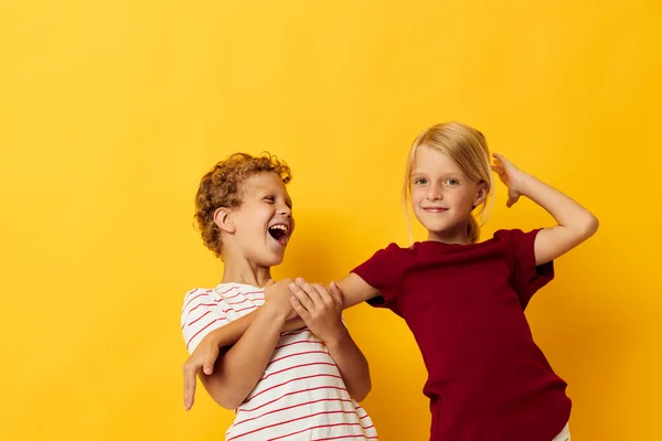 Vrolijk kinderen knuffelen mode jeugd entertainment geel achtergrond — Stockfoto