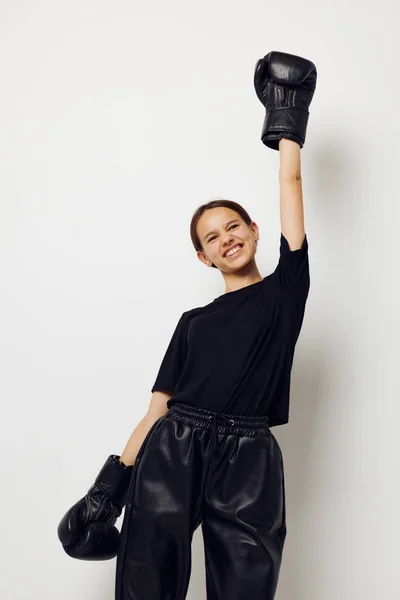 Jeune belle femme en gants de boxe en pantalon noir et un fond clair T-shirt — Photo