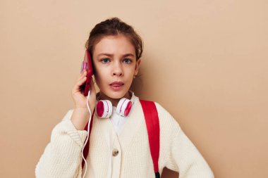 Sırt çantalı, kulaklıklı, telefon teknolojili bir kız.