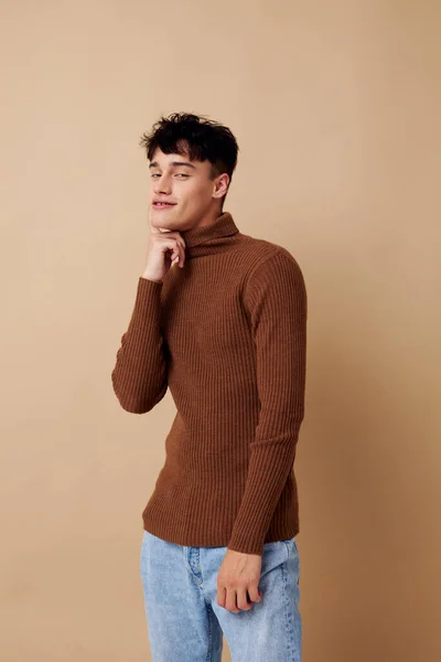 Ein junger Mann posiert in braunem Pullover selbstbewusst Mode hellen Hintergrund unverändert — Stockfoto