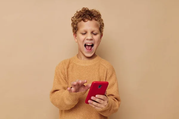 Маленький хлопчик з кучерявим волоссям червоний телефон технології весело — стокове фото