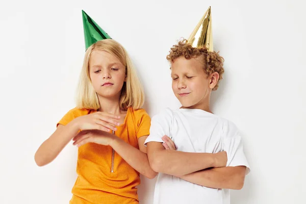 Vrolijk kinderen in veelkleurige caps verjaardag vakantie emotie geïsoleerde achtergrond ongewijzigd — Stockfoto