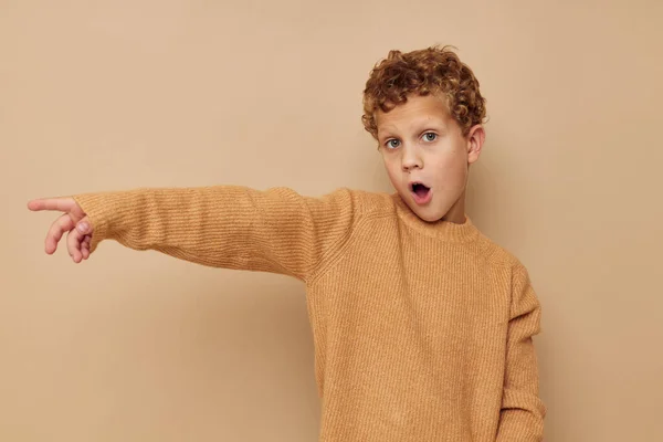 Bouclé garçon dans un pull beige posant amusant enfance inaltérée — Photo