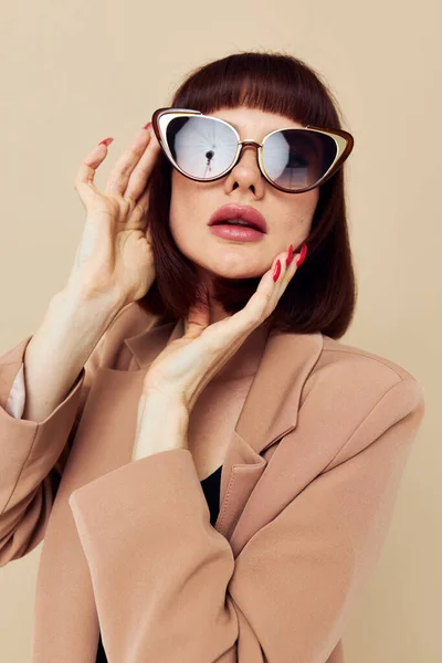 베이지 재킷을 입고우아 한 스타일의 선글라스를 끼고 있는 아름다운 여인의 사진 — 스톡 사진