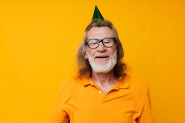 Yaşlı, kır saçlı, gözlüklü, kafasında yeşil başlık takan, tek renkli duygular çeken bir adam.