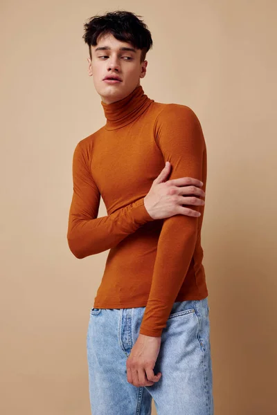 A young man brown turtleneck posing fashion light background unaltered — Φωτογραφία Αρχείου