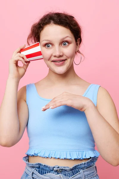 Girl drinking a drink disposable glass pink background unaltered — Stockfoto