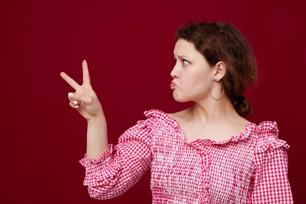 Mulher alegre rosa camisa posando gesto mão — Fotografia de Stock