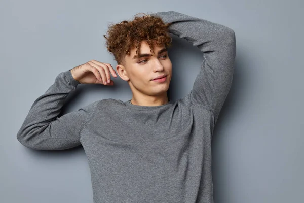 Stilig ung man i en grå sweatshirt mode studio Livsstil oförändrad — Stockfoto