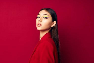 Güzel esmer moda kırmızı ceketle poz veriyor. İzole edilmiş arka plan değiştirilmemiş.