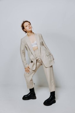 Genç bir kadının portresi klasik takım elbise modadır. Eğlenceli ışık arka planı değiştirilmemiş.