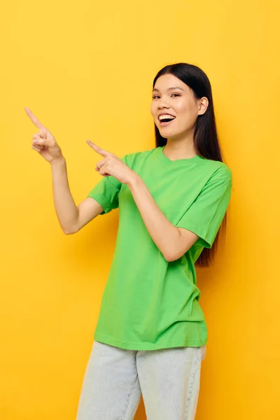 Charming young Asian woman in green t-shirts gestures with his hands emotions studio model unaltered — Stock Photo, Image