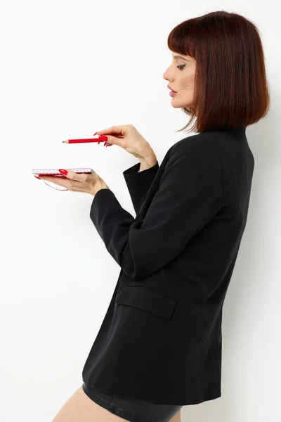 Güzel bir kadın not defterine siyah bir ceket yazıyor. — Stok fotoğraf