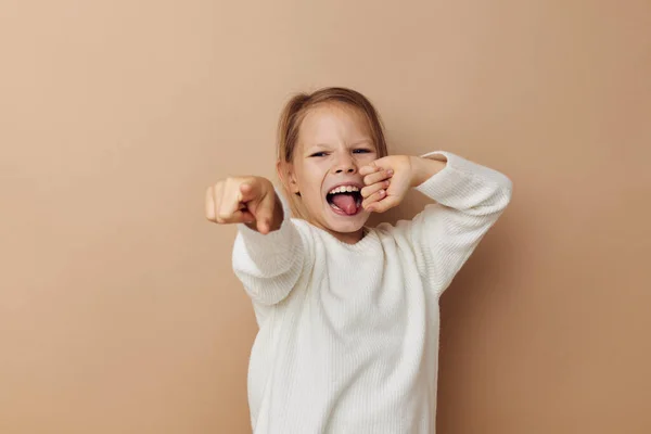 Маленькая девочка в белом свитере позирует рукой жесты детства неизменными — стоковое фото