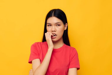 Çekici, genç Asyalı kadın elleri gündelik giysiler içinde fotokopi-uzay sarı arka planı değiştirilmeden el kol hareketleri yapıyor.
