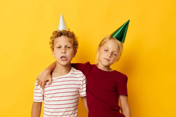 Imagen de diversión positiva de vacaciones de niño y niña con gorras en su cabeza fondo aislado —  Fotos de Stock