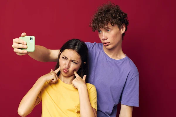 Man and woman in colorful T-shirts with a phone Youth style — Foto Stock