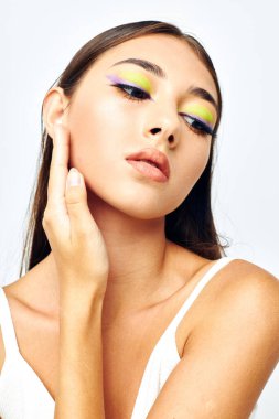 Güzel, esmer, çekici görünüş. Moda, açık arka plan pozu veriyor.