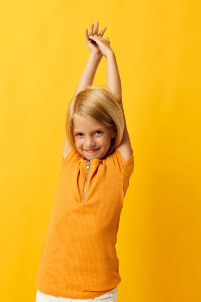 Beautiful little girl smile hand gestures posing casual wear fun yellow background unaltered — Stock fotografie