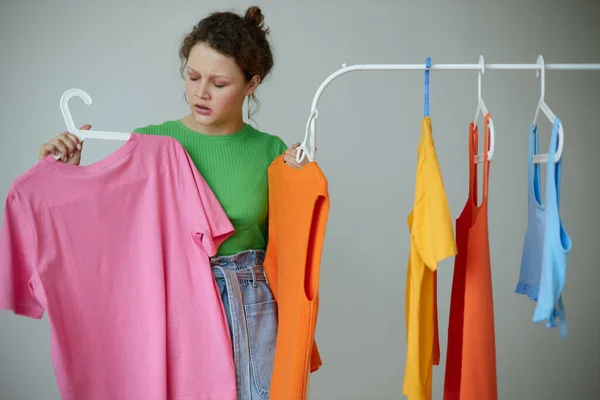 Portrait of a young woman ironing clothes on a hanger wardrobe cropped view unaltered — Stock fotografie