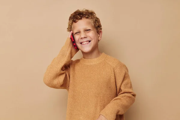 Malý chlapec ve svetru mluví do telefonu — Stock fotografie
