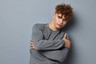 Gri kazaklı yakışıklı genç adam. Moda stüdyosu. Yaşam tarzı değişmemiş.