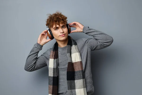 Atraktivní muž elegantní styl kostkované šála sluchátka izolované pozadí — Stock fotografie