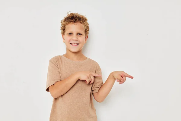 Engraçado curly menino em um branco t-shirt gestos com as mãos — Fotografia de Stock