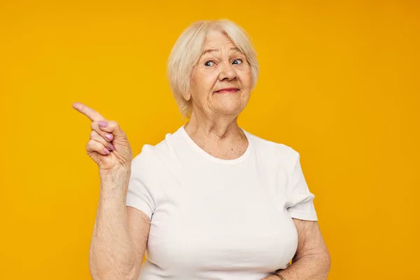 写真の退職したおばあちゃんで白いtシャツ姿楽しい黄色の背景 — ストック写真