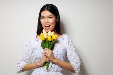 Beyaz gömlekli güzel bir esmer. Çiçekler bahar mevsimi. Yaşam tarzını değiştirmemiş.