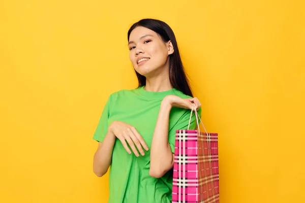 Mulher com aparência asiática pacote de compras de entretenimento isolado fundo inalterado — Fotografia de Stock