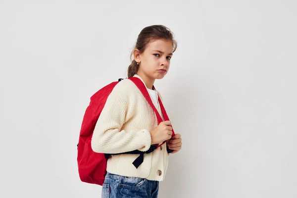 Mignon fille main geste rouge sac à dos fond clair — Photo