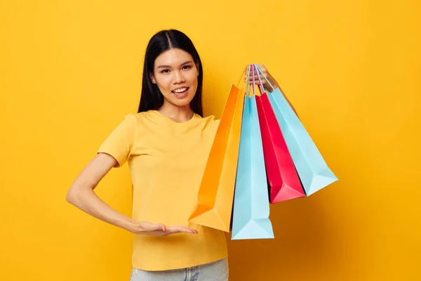Portrait Asian beautiful young woman with packages in hands shopping studio model unaltered — Stockfoto