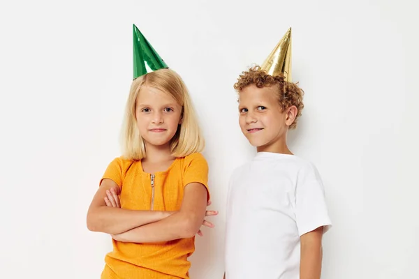 Portrait of cute children posing emotions holiday colorful caps light background — Stock Photo, Image