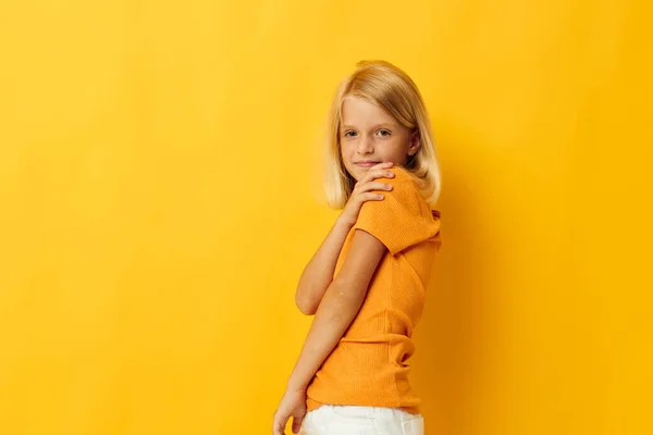 Piękna dziewczynka w żółtym t-shirt uśmiech stwarzając studio styl życia w dzieciństwie bez zmian — Zdjęcie stockowe