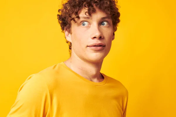 Şık gözlüklü, sarı tişörtlü, sarı arkaplan pozu veren sevimli kızıl saçlı adam. — Stok fotoğraf