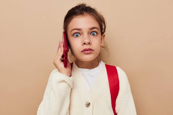 Roztomilý dívka s telefonem pózování červený batoh životní styl beze změny — Stock fotografie