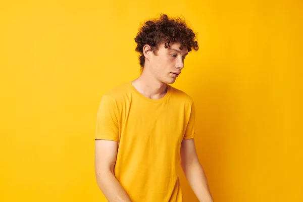 Młody, kręcone włosy mężczyzna sobie stylowy żółty t-shirt pozowanie styl życia bez zmian — Zdjęcie stockowe
