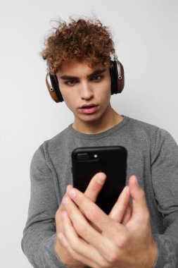 Elinde telefon olan, kulaklıkla müzik dinleyen garip bir adam.