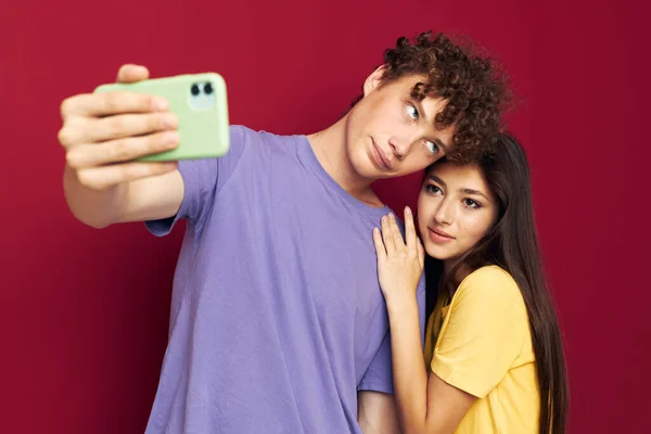 Hombre y mujer en camisetas coloridas con un teléfono Estilo juvenil — Foto de Stock