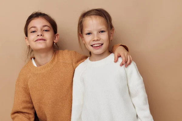 Dwa słodkie małe dziewczynki przytulić przyjaźń styl życia beżowy tło — Zdjęcie stockowe