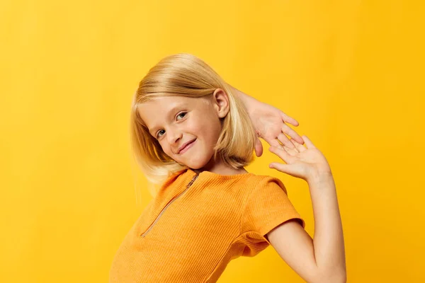 Gyönyörű kislány mosoly kéz gesztusok pózol alkalmi kopás móka sárga háttér változatlan — Stock Fotó