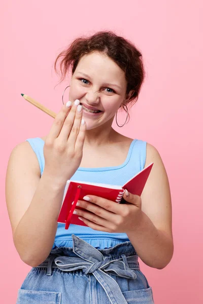 Jonge vrouw schrijven in een rood notitieboekje met een pen studie Lifestyle ongewijzigd — Stockfoto