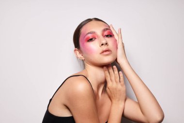 Güzel kadın gülümsüyor. Parlak pembe makyaj duyguları. Kozmetik ürünler.