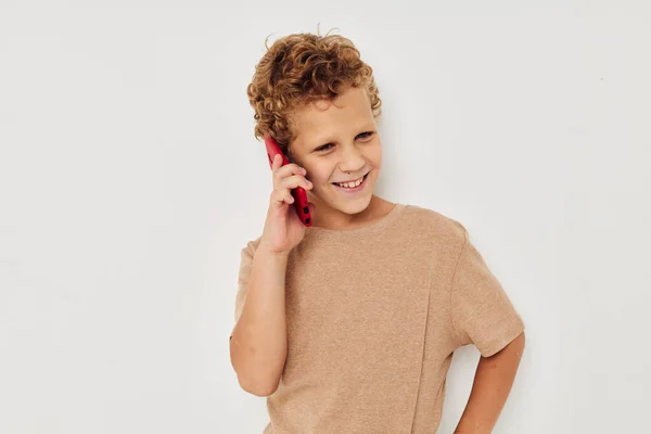 Veselý roztomilý chlapec s telefonem v ruce pózování technologie — Stock fotografie
