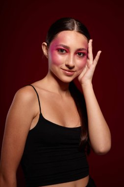 Seksi esmer kadın, el hareketleriyle lüks kozmetik ürünleri yapıyor.