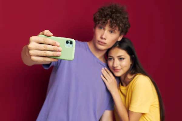 Una giovane coppia stile moderno emozioni divertimento telefono isolato sfondo — Foto Stock
