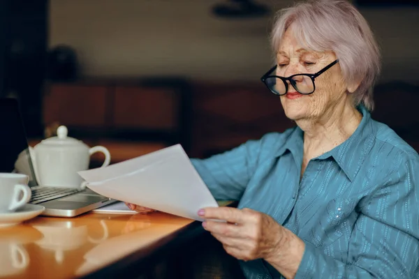 Hermosa anciana madura sentada en un café con una taza de café y un portátil Estilo de vida inalterado — Foto de Stock