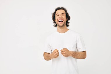 Beyaz tişörtlü neşeli adam el hareketi ile yaşam tarzını değiştirmemiş.