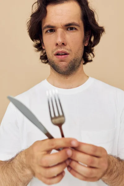 Homme attrayant dans un T-shirt blanc avec couteau avec fourchette fond isolé — Photo